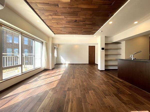 シェトワ白金台_リビングダイニングキッチンの写真 約25.3帖という開放的なLDKは、家族が自然と集まりたくなるような居心地の良さが魅力です。3LDKへ変更しても約20帖を保てるため、レイアウトの自由度はそのまま。床材には無垢ウォルナットを贅沢に使用しており、柔らかい木目と落ち着いた雰囲気が毎日の暮らしに上質なアクセントを加えてくれます。丈夫でキズがつきにくい素材なので、お子様のいるご家庭でも安心ですね。