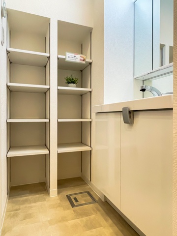 サニタリールーム サニタリールームの足元は広く、正面奥には高さのある棚が設けられています。棚板の高さは自由に調節することができますよ。リネンの他にも様々な物を収めておくことが可能です。壁には浴室乾燥機の操作パネルが設置されています。洗面台は鏡裏がキャビネットになっているほか、壁面にも収納スペースを確保。足元は備品などの保管に最適です。洗面ボウルは広々としており、雫までしっかり受け止めてくれるでしょう。