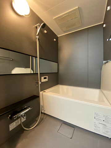 山王スカイマンション　バスルーム バスルームは全体的にダークカラーでまとめられ、大人な雰囲気♥ワイドな鏡が開放感をもたらしており、シックながら居心地の良い空間です。追い焚き機能があれば、いつでも温かいお風呂に入ることができますね。さらに、嬉しい浴室換気乾燥機を搭載。
