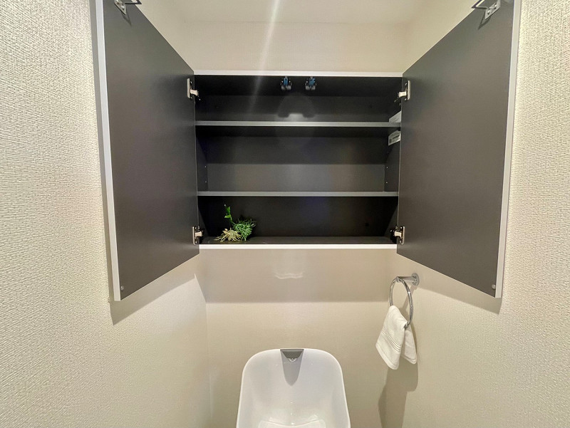 トイレ収納　柳橋リバーサイドマンション トイレ内の収納は頭上の吊戸棚。トイレットペーパーなどのストック類や掃除用具など、生活感のないスッキリ空間に。