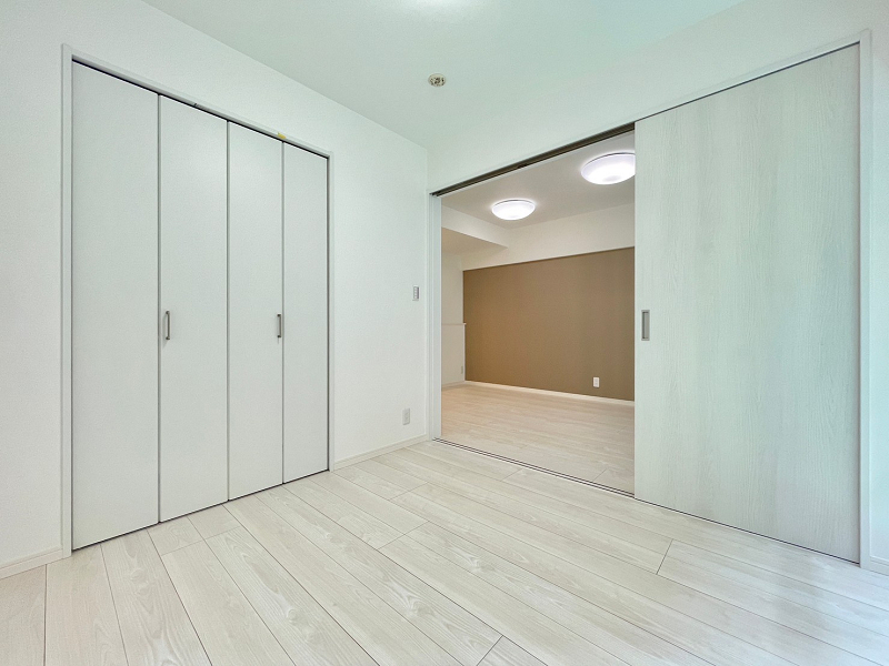 中島第一ビル　寝室 リビングダイニングに隣接する洋室は約4.8帖です。大きく開くスライドドアによって仕切られているので、開けたまま大きなワンルームのように使うことも可能◎エアコンを使用する際は扉を閉めておくと、効率良くお部屋の温度を調節できますね。