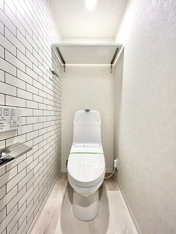 トイレ サブウェイタイル風のアクセントウォールをセレクトしたトイレは、ホワイトで清潔感がありながら海外風インテリアに仕上がりました。トイレットペーパーや掃除用品などの備品は上部の可動棚へどうぞ♪