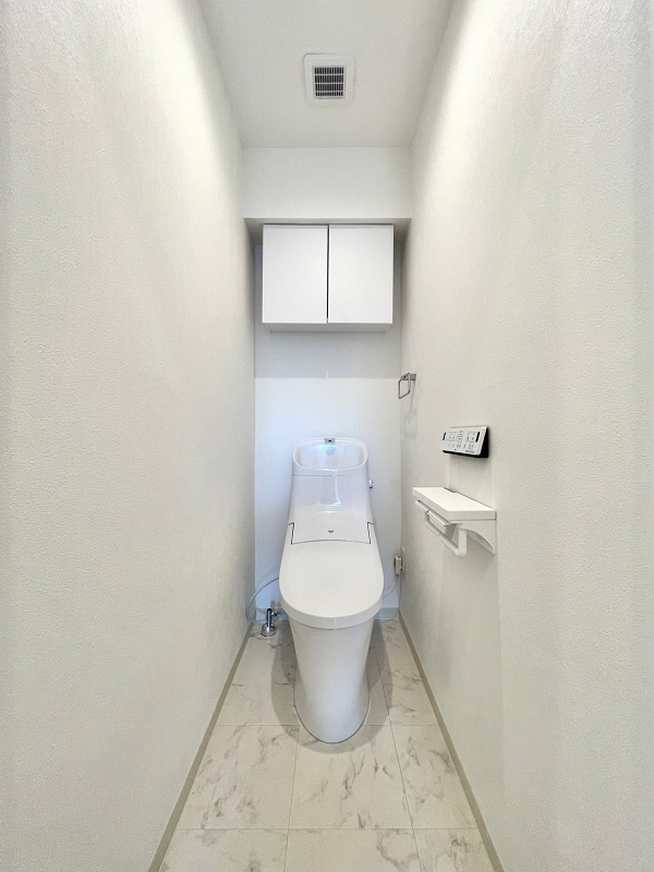 トイレ 清潔感のあるホワイトで統一されたトイレは大理石調の床タイルをセレクトし、高級感のある空間に❀トイレは節水効果が見込まれる手洗い一体型を採用し、温水洗浄便座を完備していますよ。トイレットペーパーなどの備品は吊り戸棚へどうぞ。