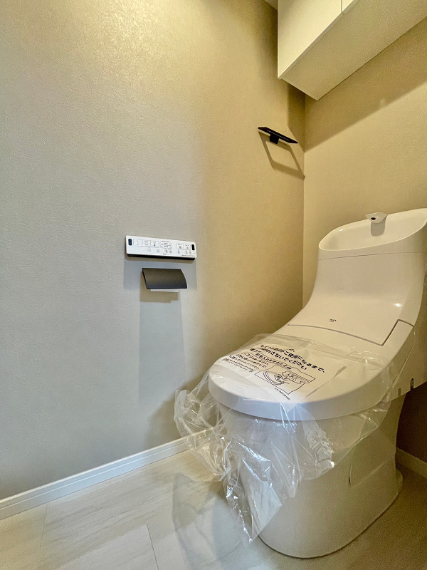 トイレA 手洗い一体型トイレは温水洗浄便座を採用しており、冬場でもヒヤッとすることなく快適にご利用いただけます。吊戸棚は、トイレットペーパーや掃除用具などをしまっておくのに最適ですよ。
