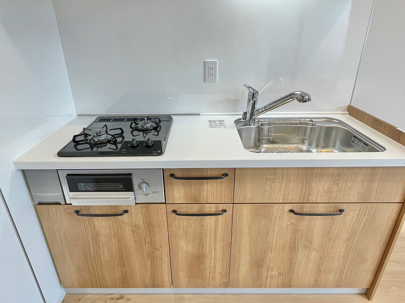 キッチンA ウッドテイストの壁付けキッチン。グリル付き2口コンロや浄水器付き水栓が備え付けられています。効率よくお料理ができるため、食卓のレパートリーを増やすことができそう◎家事の時短も期待できますね♪