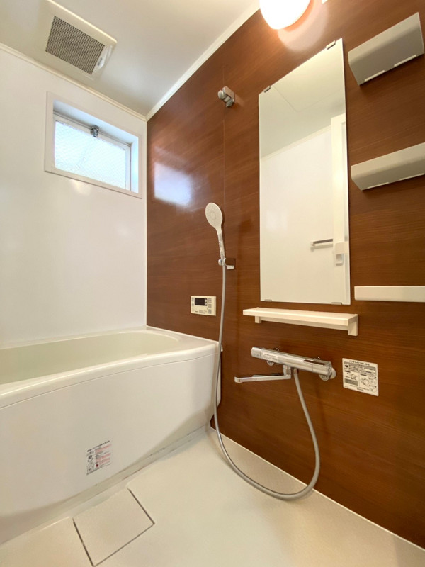 バスルーム　上馬第2コーポラス 小窓付きのバスルーム。使用後やお掃除の際の換気に役立ちますね。ブラウンの木目調デザインがリラックス空間を演出しています。追い焚き機能が付いているので、長湯をしがちな方にピッタリ♡