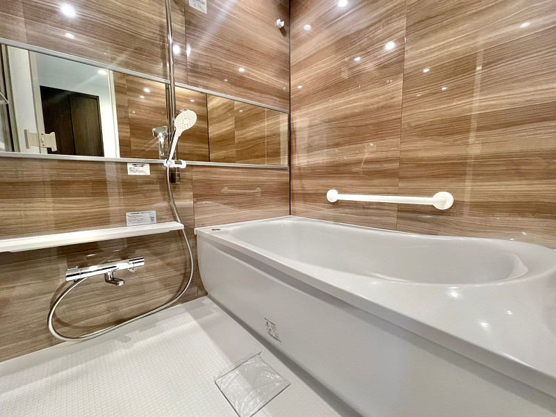 バスルーム　ランドステージ池上 バスルームは優しい木目調のタイルが品のある印象を与えてくれますね。バスタブには手すりが付いているので、転倒防止にもなります。浴室乾燥機や追い焚き機能があれば快適なバスタイムをお過ごしいただくことができますよ♪