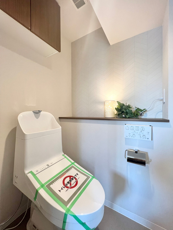 トイレ 温水洗浄便座付きのトイレは廊下の独立スペースにあります。カウンターにお好みのインテリアなどを飾れば、おしゃれな空間にカスタマイズすることもできますね。吊戸棚には掃除用具や予備の備品などをしまっておけます。