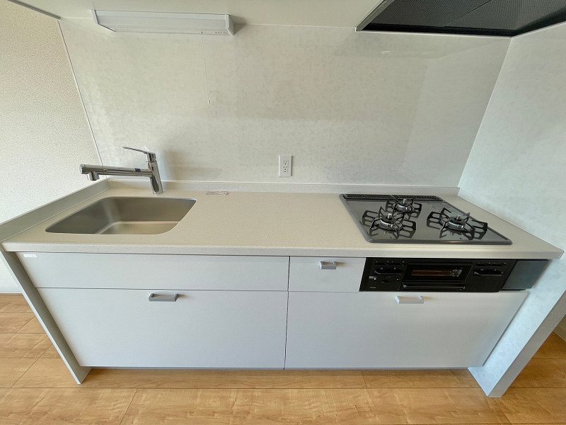 キッチン 白を基調とした清潔感溢れる壁付けキッチンには、3口コンロや浄水器付き水栓が備え付けられていますよ。効率よく料理ができ、食卓のレパートリーが増えそうですね。かさばる調理器具や鍋などもしまっておける収納スペースもしっかり確保しています✨