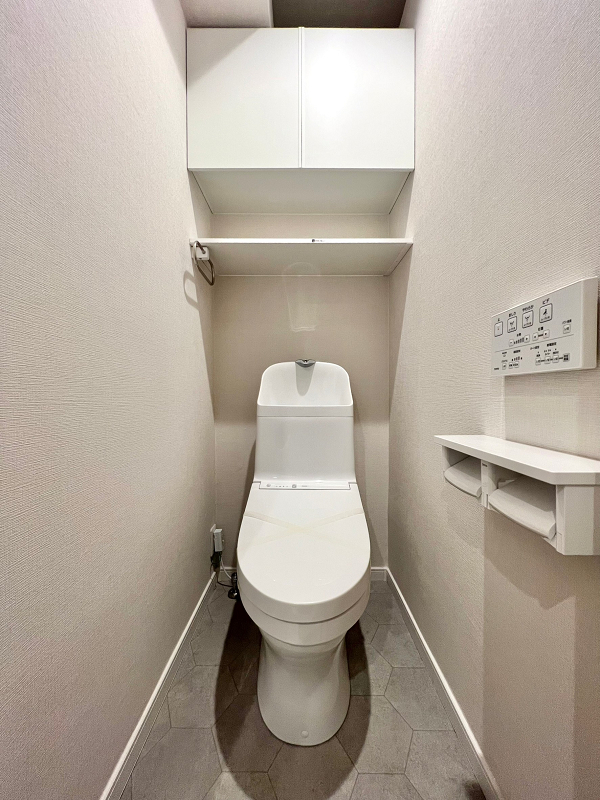スターハイツ八幡山　トイレ 床に施されたヘキサゴンタイルが目を惹くトイレはサニタリールームとは別の独立空間です。手洗い一体型のトイレは節水効果が見込まれるほか、各パーツの繋ぎ目や凹凸が少ないため、掃除が行き届きやすいのがメリット◎トイレットペーパーなどの備品は吊り戸棚へどうぞ。