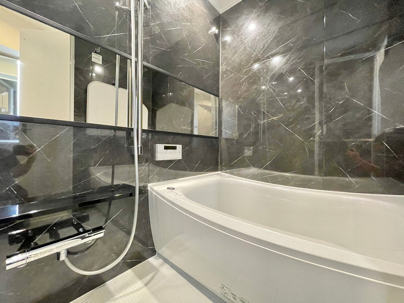 MKC神泉ハイツ　浴室 バスルームはツヤツヤとした黒い大理石調のパネル貼り♡自然な光沢が高級感を演出します。黒をアクセントとするこちらのお部屋によく似合っていました。浴室乾燥機を搭載しているため、湿気対策は万全◎雨の日にお洗濯物を干す場所としても使えて非常に便利ですよ。