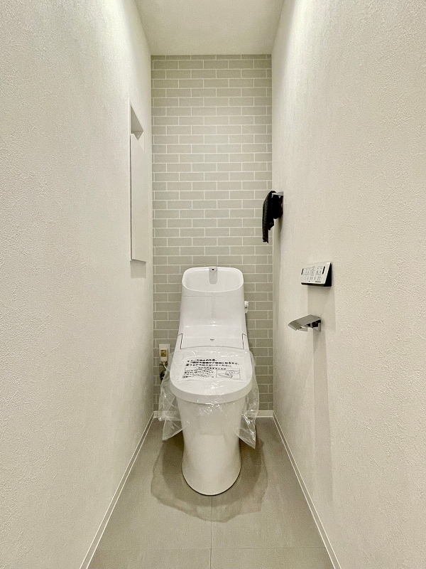 トイレ タイル柄のアクセントクロスが印象的な独立空間のトイレは手洗い一体型を採用。清潔感溢れる内装ですね。お掃除がしやすく、使用後すぐに手を洗えるので衛生的ですよ。温水洗浄便座は寒い日でも快適にご利用いただけます。