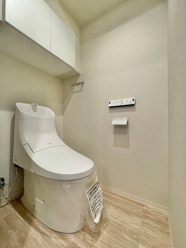 トイレ　セブンスターマンション西五反田 シンプルな温水洗浄便座付きトイレは手洗い一体型を採用しています。使用後すぐに手を洗うことができるため衛生的。節水効果も期待できますよ。凹凸が少ない造りのためお掃除がしやすいのも特徴です。吊戸棚には掃除用品やトイレットペーパーなどをしまっていただけますよ。