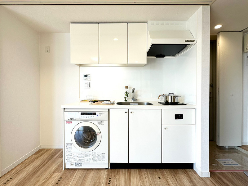 トゥールブランシュ麻布　キッチン　洗濯機 キッチンは壁付タイプを採用。左下にはドラム式洗濯機を収納できるスペースがあります。IHクッキングヒーターやレンジフードを搭載。IHは火を使わないためどの年代の方でも安全にご使用いただけます。調理器具は吊戸棚とキッチン収納へどうぞ♪
