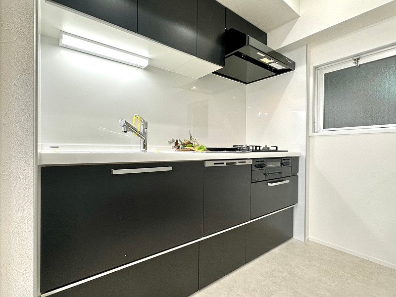 中央ビルディング　キッチン 黒いパネルでシックな印象を与えてくれているキッチン。壁付タイプは、お料理に集中して取り組むことができるメリットがあるんですよ✨内倒し窓が付いているため、換気をしながらお料理が可能です。食洗機をはじめとした便利な設備も備わっています。