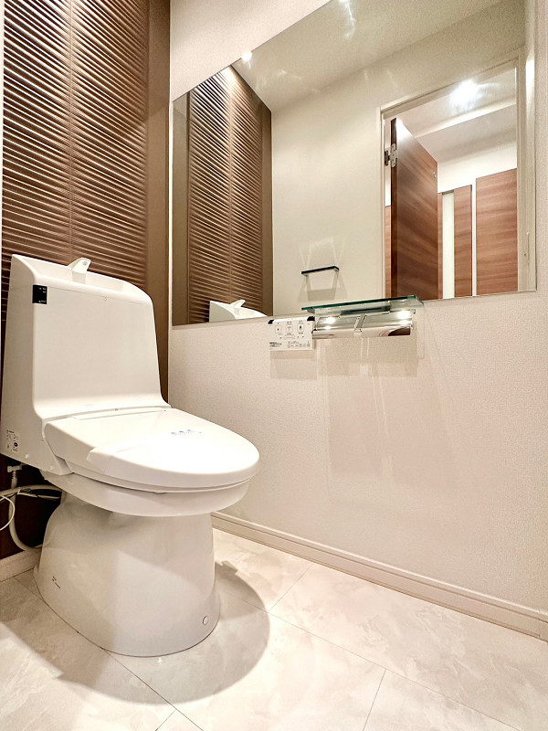 光建ハイム日本橋　トイレ トイレは廊下の独立スペースに設けられています。ブラウンのクロスが落ち着いた空間を演出✨左手には大きな鏡が付いていましたよ。トイレットペーパーホルダーはカウンター付きで、スマホなどの小物を一時的に置くことが可能。