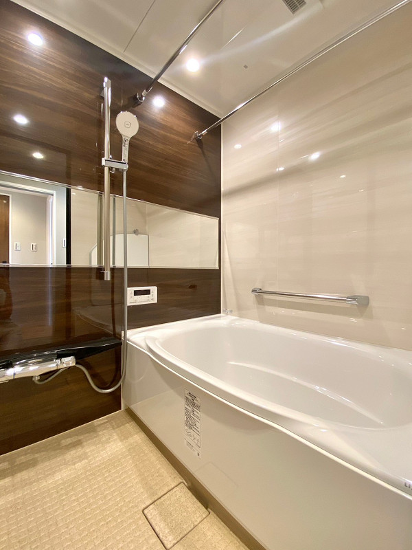 コスモ千歳烏山ロイヤルフォルム　バスルーム バスルームは濃いブラウンの木目調デザインパネルが施され、高級感あふれる空間に🛀バスタブにはアームレストや手すり、滑り止め加工が付いており、快適な入浴タイムをサポートしてくれます。もちろん浴室乾燥機や追い焚き機能などの便利機能も備わっていますよ。