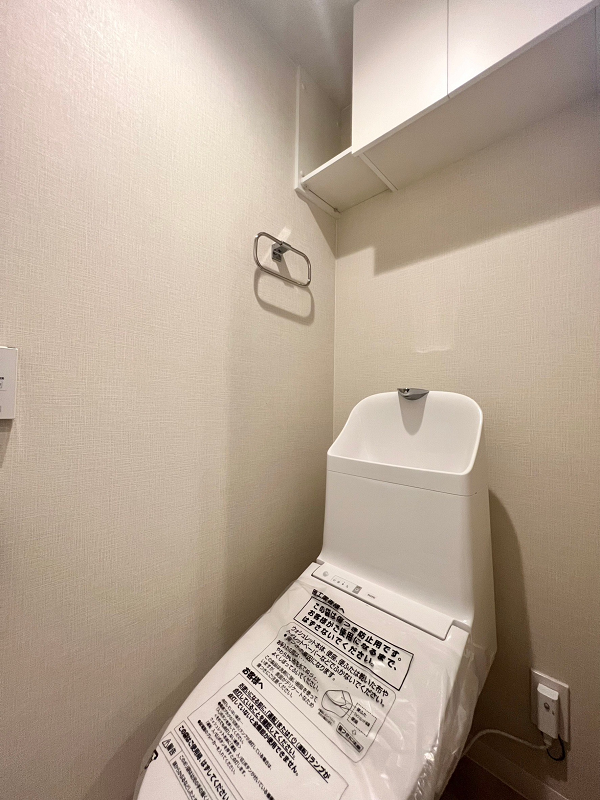 ジュウェル小石川　トイレ トイレはサニタリールーム内に設けられていました。節水効果のある手洗い一体型のトイレをセレクトし、光熱費の節約に繋がります◎また、溝や隙間が少ない造りのため日頃のお手入れがしやすいのもポイント♬上部の収納を活用し、綺麗なトイレ空間を保ちましょう。