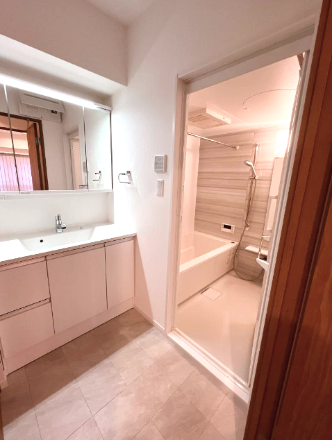 日本橋アビタシオン　サニタリールーム サニタリールームは、トイレ・洗面化粧台・バスルームがまとまった造り。洗面化粧台はヘアセットに便利な3面鏡仕様です。木目調のパネルが使用された浴室は、ホッと心が落ち着きそう♡浴室乾燥機や追い焚き機能など、あると嬉しい設備もしっかり備わっていますよ✦