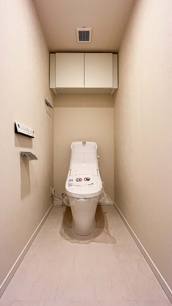 クレッセント東京ビュータワー　トイレ トイレは廊下の独立空間にありました。毎日使う空間はシンプルなデザインが1番ですよね✨手洗い一体型は、なんと節水効果が期待できるんですよ。トイレットペーパーといった備品の収納には吊戸棚をご利用ください。扉付きで中身が見えないのも嬉しいポイントです◎