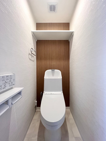 成城エコーハイツ　トイレ トイレはサニタリールームとは別の独立トイレ。背面の壁に木目のアクセントウォールが施され、空間をお洒落に彩っています。手洗い一体型のトイレは節水効果が見込まれるほか、各パーツの繋ぎ目や凹凸が少ないため、お手入れが行き届きやすいのがメリット💕温水洗浄便座機能付きでオールシーズン快適にご使用いただけますよ。