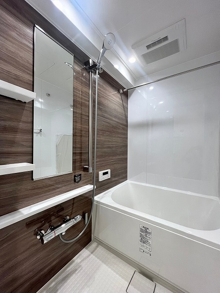 シャトレー笹塚　バスルーム 鏡面パネルの輝きが美しい木目デザインのバスルームは1116サイズを採用。追い焚き機能を完備しているので、ご家族で入浴時間が異なっても温かい湯船で疲れを癒していただけます。浴室乾燥機は衣類乾燥にはもちろん、冬場には暖房機能で快適なバスタイムをご堪能いただけますね✧