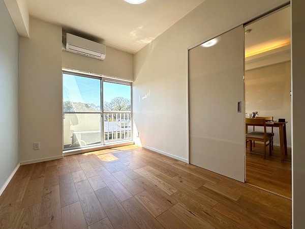 都立大パレス__南向きの洋室の写真 バルコニーに面した、おおよそ5.7帖のお部屋には大容量のクローゼットを完備しています。季節もののコートや丈の長いワンピースなども綺麗に保管できる便利なスペース。エアコン付きなので、引越し直後から快適な暮らしをスタートできます。