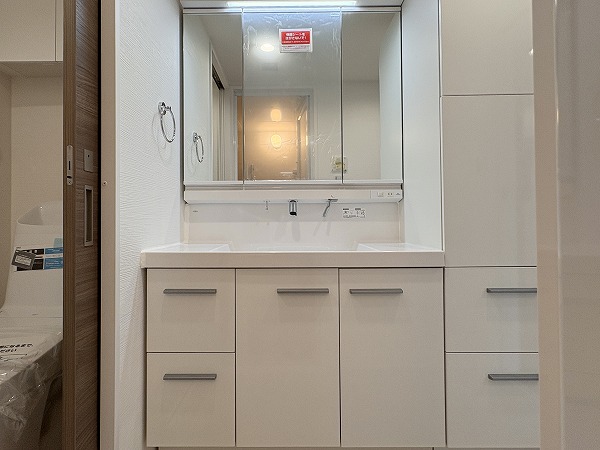 サンピア幡ヶ谷公園_洗面化粧台の写真 ホワイトを基調とした独立洗面化粧台は、3面タイプのミラーキャビネット式。身支度の際、サイドや後頭部まで確認できるのでスムーズに準備ができそうです。収納スペースがたっぷりと取り付けられているので、衛生用品や化粧品などをストックしておくのに便利ですね◎