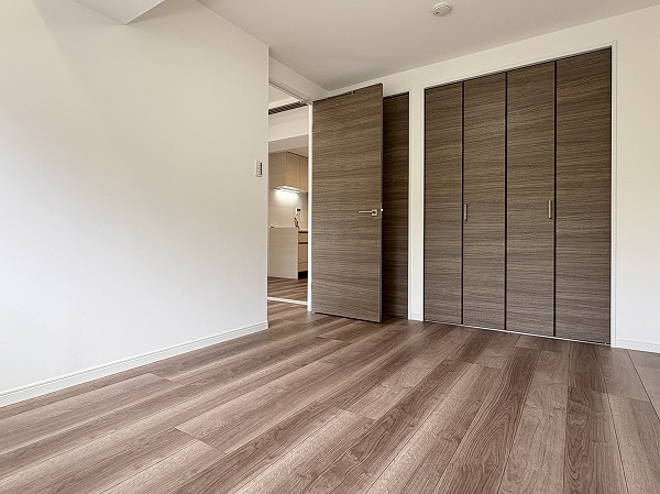 サンピア幡ヶ谷公園_洋室の写真 約6.0帖の洋室は、ホワイトのクロスと木目調のフローリングがナチュラルで温かみのある雰囲気を演出しています。どんな色の家具やカーテンも合わせやすいのが嬉しいポイント◎クローゼットが2つ設置されていたので、衣装持ちの方も安心ですよ。