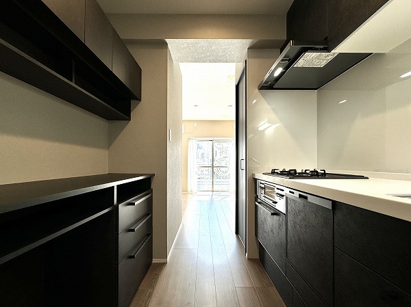 マンション西目黒苑_キッチンの写真3 モノトーンの配色が際立つキッチンは、シンプルながらも上質さを感じさせる洗練空間。無駄のない壁付け型のレイアウトで、お料理にしっかりと集中できる設計です。背面にはたっぷり収納できるカップボードを完備し、日常使いの食器やキッチン家電もすっきり整頓。