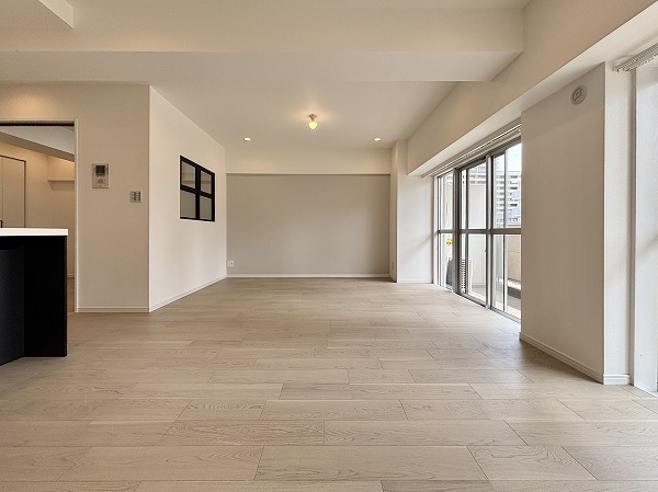 月島ホームズ_日当たり良好なリビングダイニングキッチンの写真 約17.9帖のリビングダイニングキッチンは、家具の配置を自由に楽しめるゆとりの広さ。白を基調としたシンプルなフローリングとクロスに、グレーのアクセントクロスが上品に映え、アートや壁掛けテレビを取り入れるだけで空間に個性を添えられるデザインに仕上がっていますよ♩