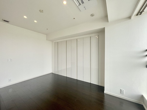 ザ・パークハウス西麻布レジデンス_ベッドを置ける主寝室の写真 リビングダイニングからアクセスできる、主寝室にぴったりの洋室は約8.6帖。大きめのベッドを置いてもゆとりがあり、夫婦での使用にも十分な広さです。さらに、壁一面の収納スペースには洋服や小物をしっかり整理できるため、毎日の生活もスッキリ快適◎