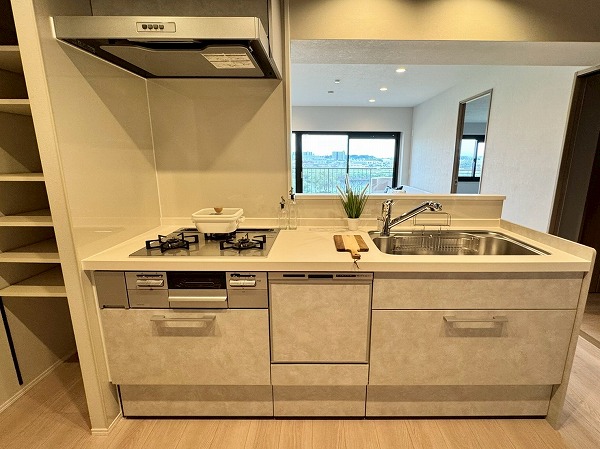 多摩川ハイム2号棟_キッチンの写真6 しっかりと収納が確保されたセミオープンタイプのキッチンスペース。オープンキッチンのような開放感と、クローズドキッチンのようなプライバシー・集中できる環境を両立できます。グリル付きの3口コンロや食洗機も完備されており、効率良く料理をすることができそうですね。また浄水器付きの蛇口から綺麗なお水をお手軽にご利用いけます。