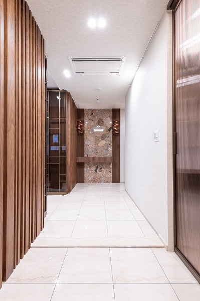 ラ・トゥール千代田_広々とした玄関廊下の写真 玄関はホテルライクな雰囲気が漂う佇まい。段差が少ない設計で、幅広い世代に優しい造りになっています。右手には奥行きのあるシューズインクローゼットがあり、ご家族全員分の靴をしっかり収納可能です。