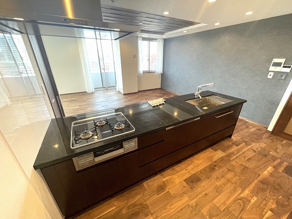 芝パークタワー_お洒落なキッチンの写真 シックなモノトーンで仕上げられたシステムキッチン。正面の窓からは陽光と景色が差し込み、料理の時間が自然と心地よいひと時に。ゆとりあるワークトップは作業スペースとしても余裕たっぷりで、効率よく快適に調理を楽しめるのが魅力です。