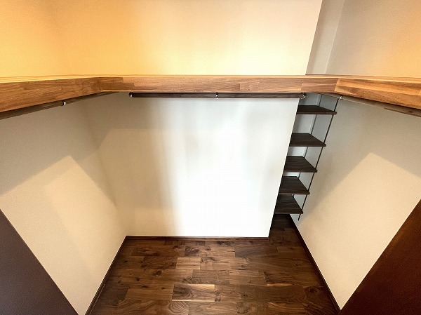 芝パークタワー_ウォークインクローゼット付きの洋室の写真 ウォークインクローゼットは、木の温もりが感じられるフローリングと枕棚が特徴。収納力が高く、服や小物を整理整頓できるのはもちろん、自然素材のぬくもりが日常にほっとした安らぎをプラス。朝の身支度も、ここに立つだけで気分が上がる特別な空間です❀