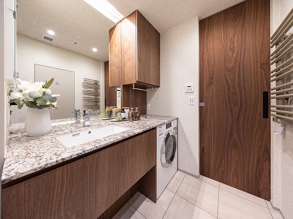 ラ・トゥール千代田_広々としたパウダールームの写真 パウダールームには、インパクト社製の特注洗面化粧台を採用。ラグジュアリーなデザインが目を引きます。カウンター下には洗濯乾燥機を新設し、すっきりとした空間を保ちながら機能性も確保しています。