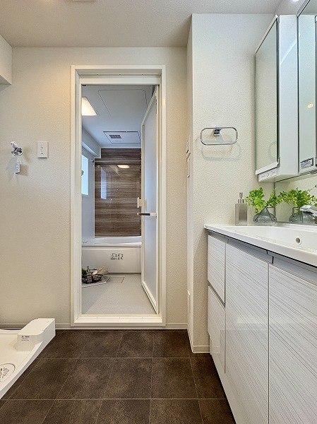 朝日プラザ旗の台_お洒落な水回り設備の写真 バスルーム手前のパウダールームには洗面化粧台と洗濯機置き場が配置されています。広すぎず狭すぎず、1～2人で使うのにちょうどいいサイズ感。洗濯機置き場にはラックが付いており、洗剤や洗濯ネットの置き場に困りません。