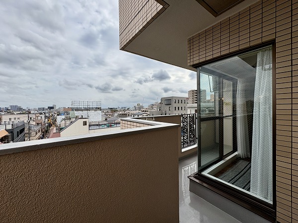 朝日プラザ旗の台_ワイドなバルコニーの写真 お部屋の形に添って設けられたバルコニー。角部分がガラス窓になっているのがポイントです。大通りと反対側の住宅街に面しており、落ち着いた印象の眺望でした。近くに大きな建物はなく、周辺からの視線も気になりません◎