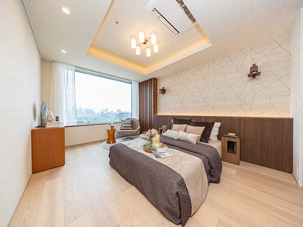 ラ・トゥール千代田_広々とした洋室の写真 約10.0帖の洋室はキングサイズのベッドもゆったり配置でき、ご夫婦の主寝室に最適。クロスやウッドパネルを活かした洗練されたデザインに加え、大きなウォークインクローゼットが備わっているのも魅力です。