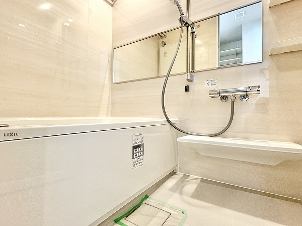 第15宮庭マンション_ベージュカラーのバスルームの写真 明るい色味のバスパネルが空間に清潔感と爽やかさをもたらしているバスルーム。浴室乾燥機が搭載されているので、浴室内の湿気防止や雨の日のお洗濯にも大活躍しそう◎快適なご入浴に欠かせない追い焚き機能も付いていますよ。