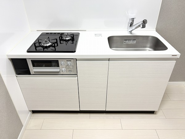 アルム幡ヶ谷_使いやすそうなキッチンの写真 シンプルでありながらも清潔感があふれているシステムキッチンは、お料理に集中しやすい壁付け型です。上下に収納が設置されているため、キッチン用品をすっきりとしまっておくことができます。2口コンロとグリル付きで毎日の家事がはかどりそう✨