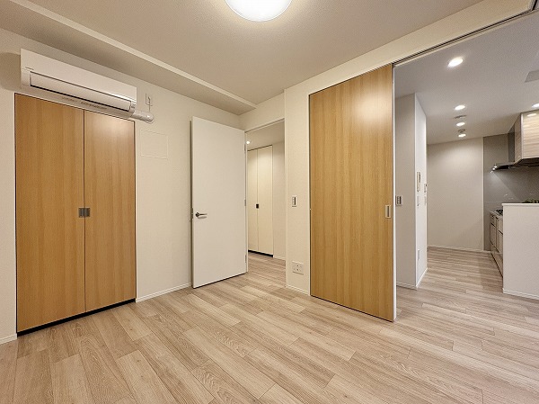 クラッシィハウス世田谷公園_木目調の扉の写真 約5.0帖の洋室はメインルームとスライドドアでつながり、廊下からも出入りできる便利な動線設計。クローゼットを備えているため収納力も十分で、生活用品や衣類の整理にも困りません。落ち着いた空間は子ども部屋や書斎など、さまざまな用途に対応できますよ。