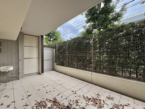 クラッシィハウス世田谷公園_バルコニーの写真 タイル張りのテラスは雨水で自然に清掃されるので手入れが簡単。1階ですが緑の目隠しが設置されているためプライバシーも守られ、周囲の視線を気にせず過ごせます。朝のひとときにチェアでコーヒーを楽しむなど、のんびりした時間を満喫できるアウトドアスペースです。